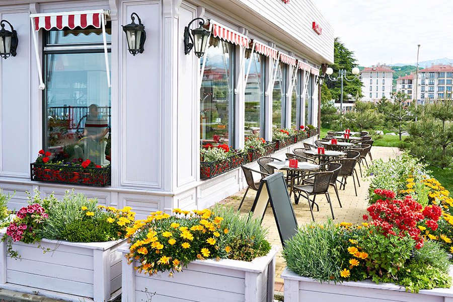 Specialized Business Insurance - Bright Looking Restaurant with Blooming Flowers with Striped Awnings